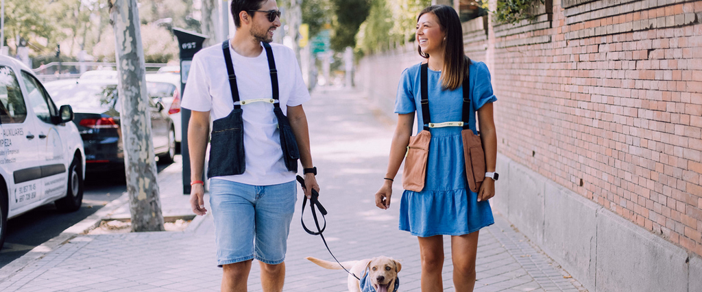 Chico y chica paseando a un perro con su bolso Movers Bag puesto